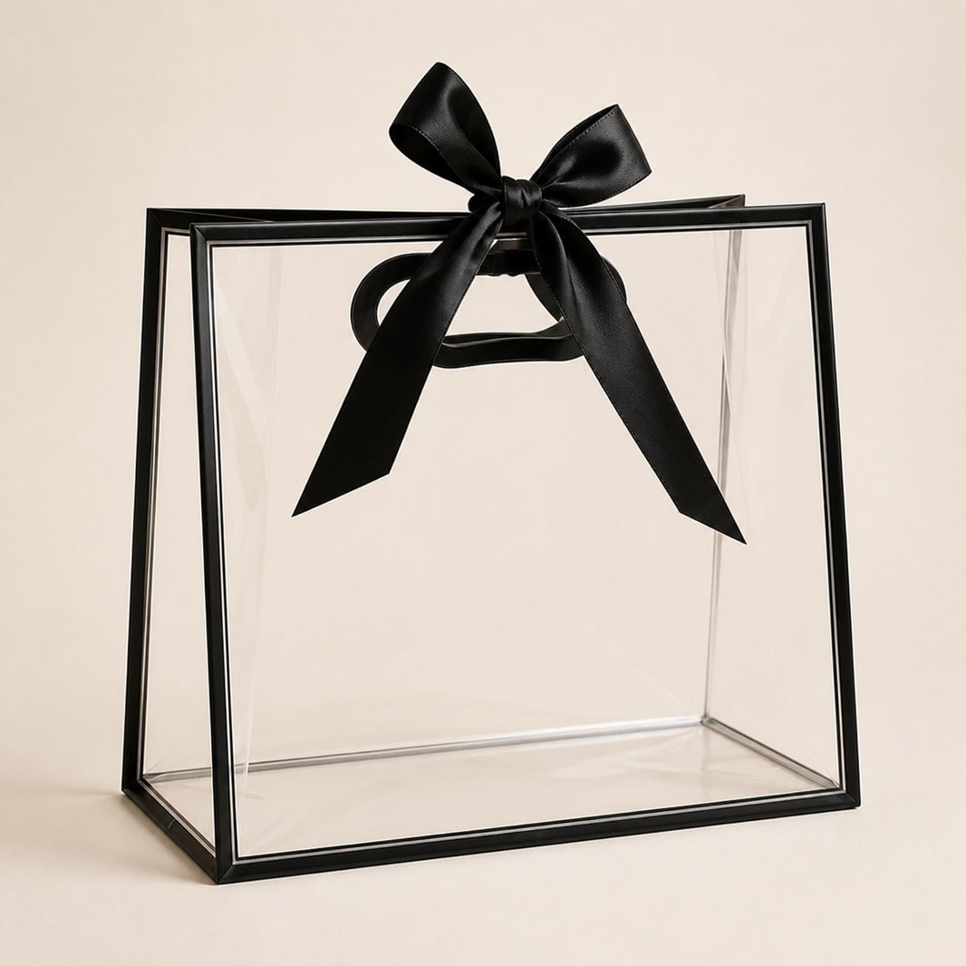 Empty clear presentation gift bag with black edging, oval handle and wide black satin ribbon bow