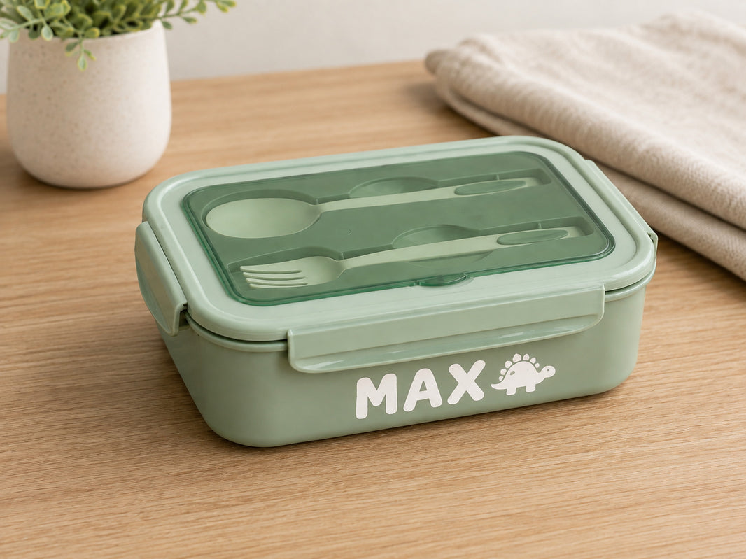 Green bento lunch box personalised with the name Max and a dinosaur icon in white vinyl