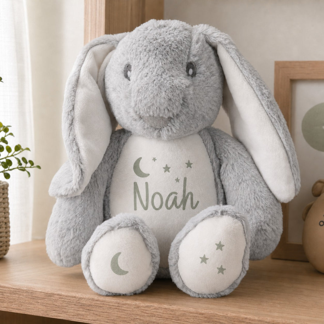 Personalised grey bunny rabbit teddy with moon and stars design and the name Noah on a wooden shelf