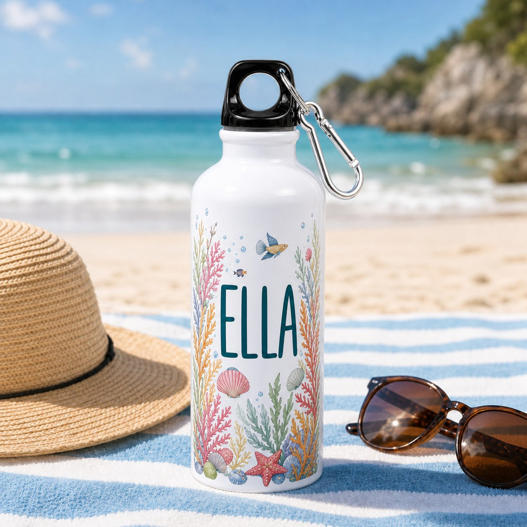 Personalised water bottle with seaside shell design and the name Ella on a beach towel
