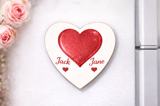 Heart-shaped decorative plaque with 'Jack' and 'Jane' on a white surface with pink roses.