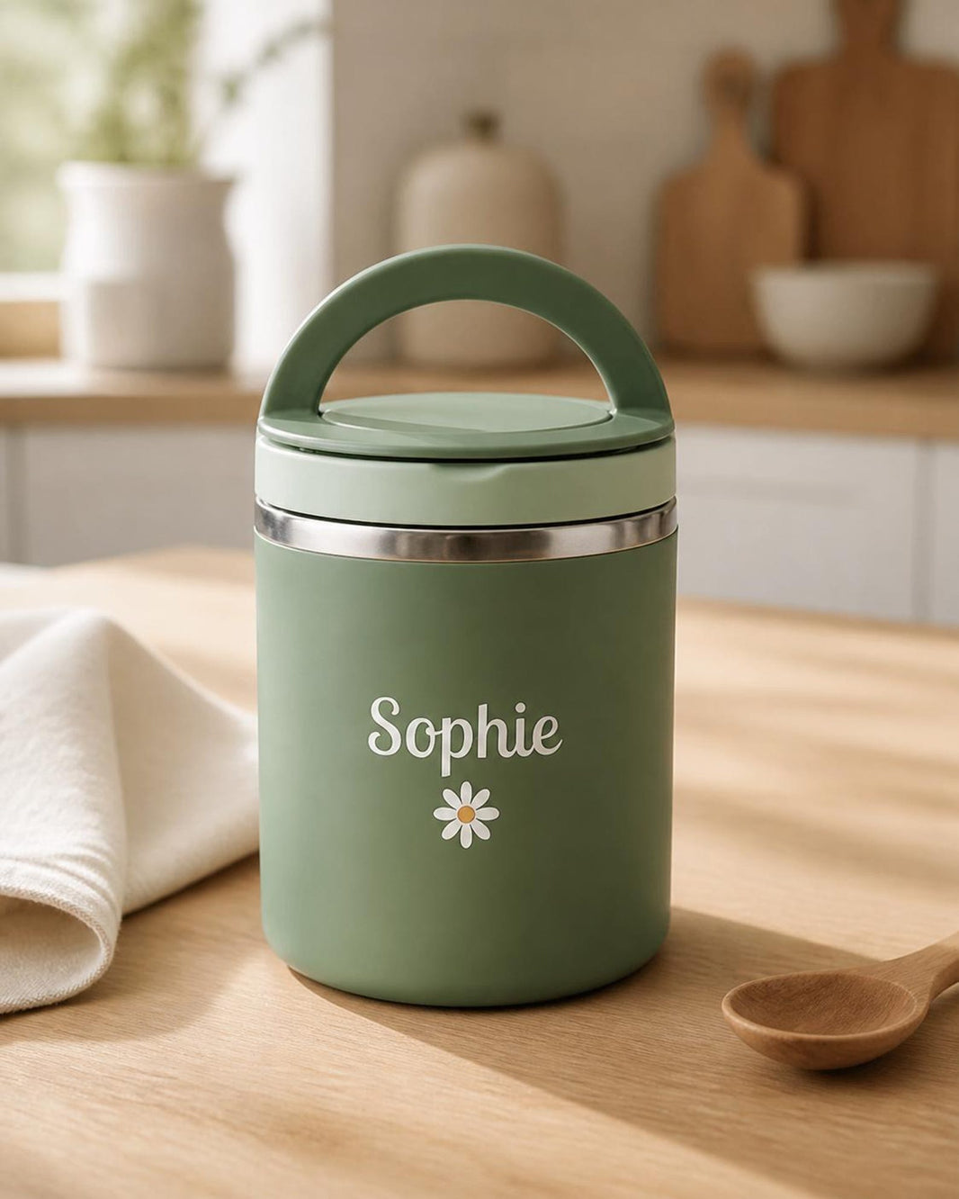 Green personalised food jar printed Sophie with a daisy on a wooden kitchen worktop