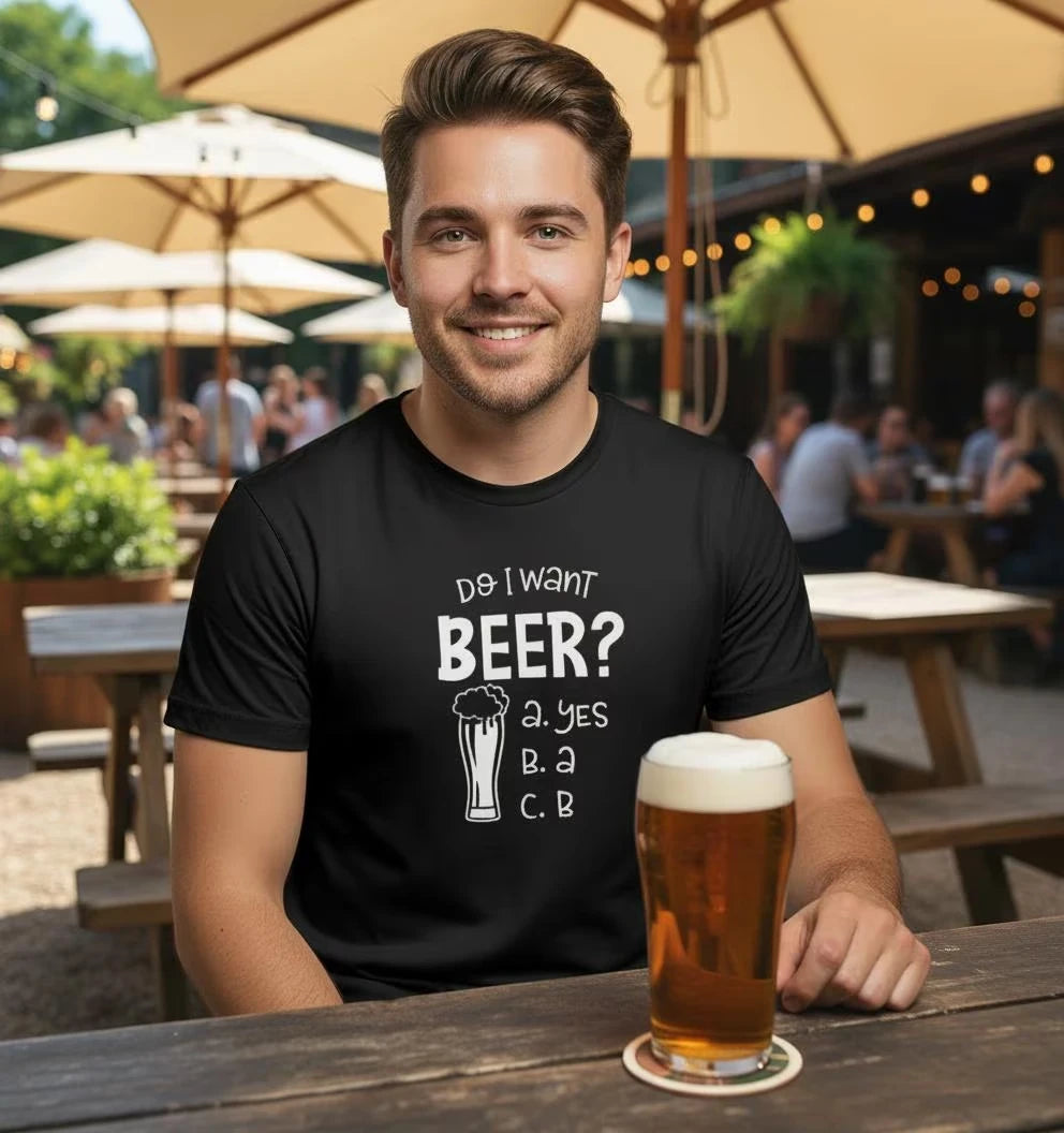 Man wearing a black t-shirt with a beer-themed question on it, sitting at an outdoor bar.
