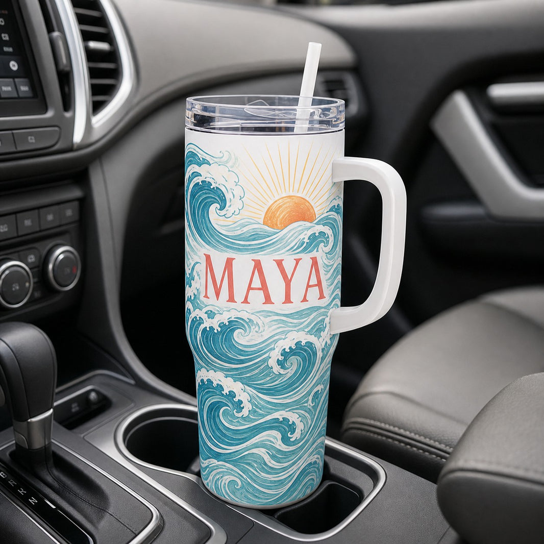 Personalised 40oz tumbler with ocean wave design and the name Maya sitting in a car cup holder
