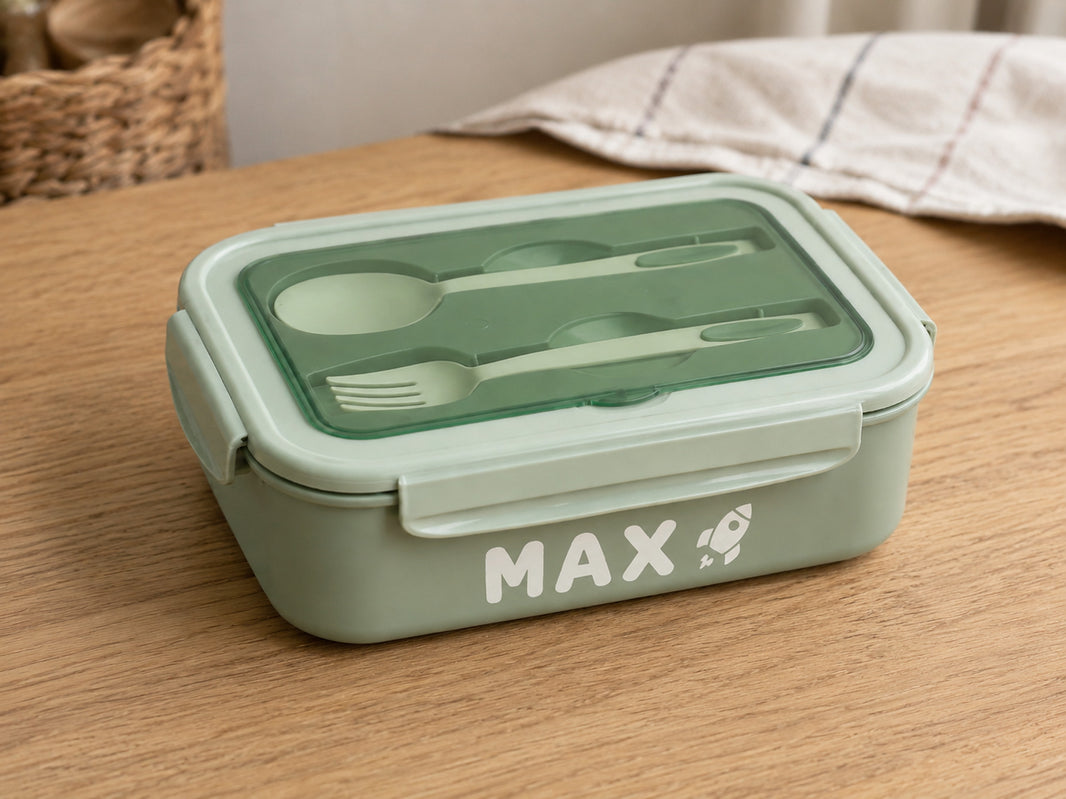 Green bento lunch box personalised with the name Max and a rocket icon in white vinyl
