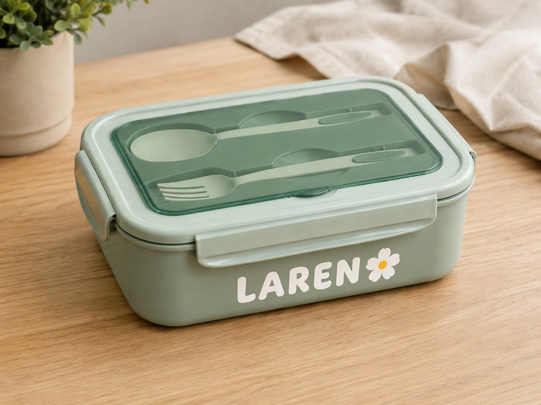 Bento lunch box with spoon and fork stored in the clear lid and a personalised name on the front