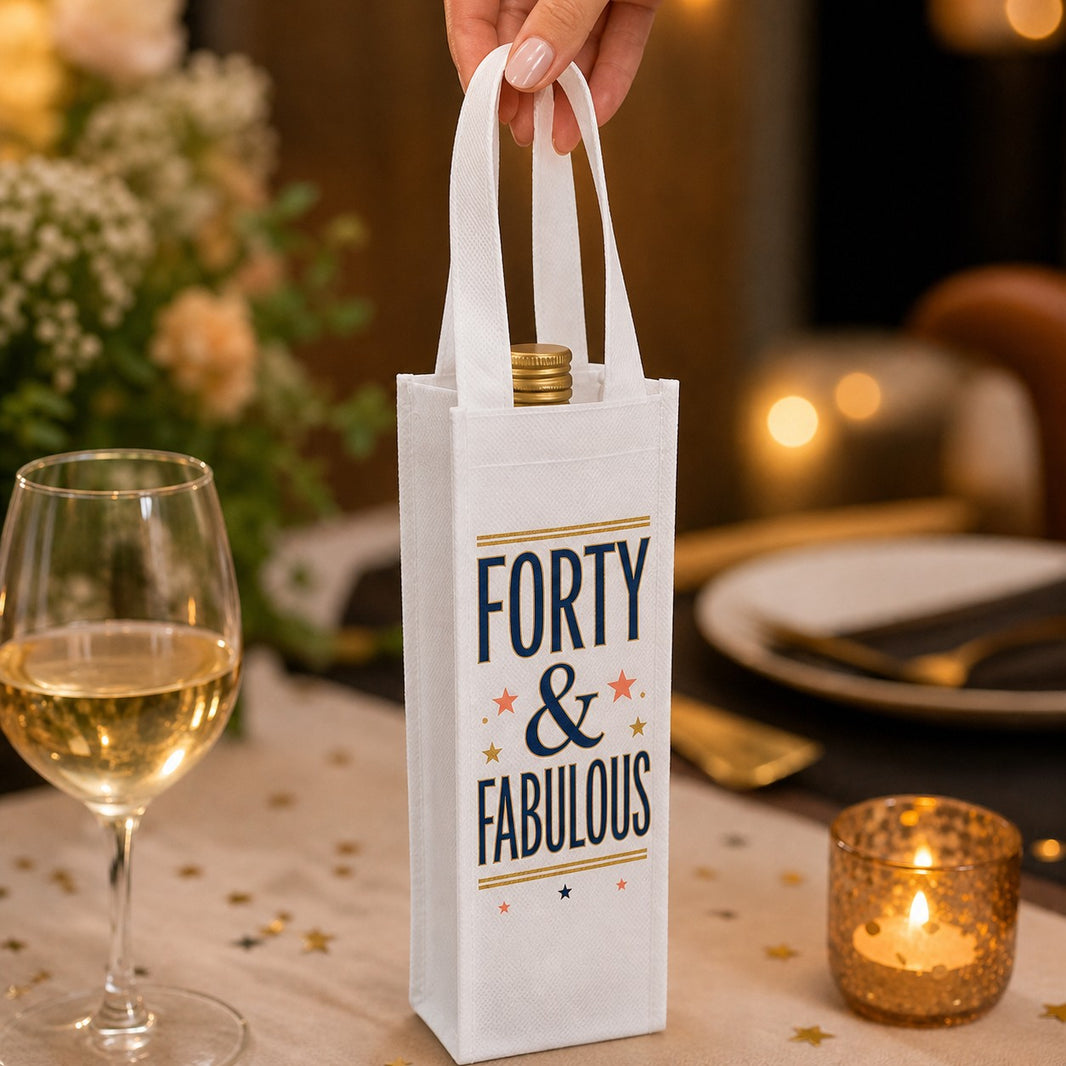Hand holding a Forty and Fabulous personalised mini wine bottle bag at a birthday dinner table
