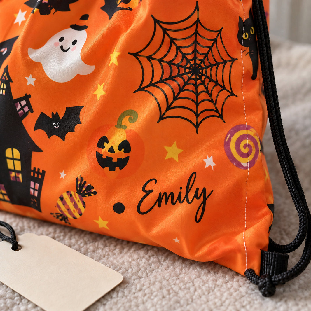 Close-up of the name Emily printed in black script lettering on an orange polyester Halloween drawstring bag