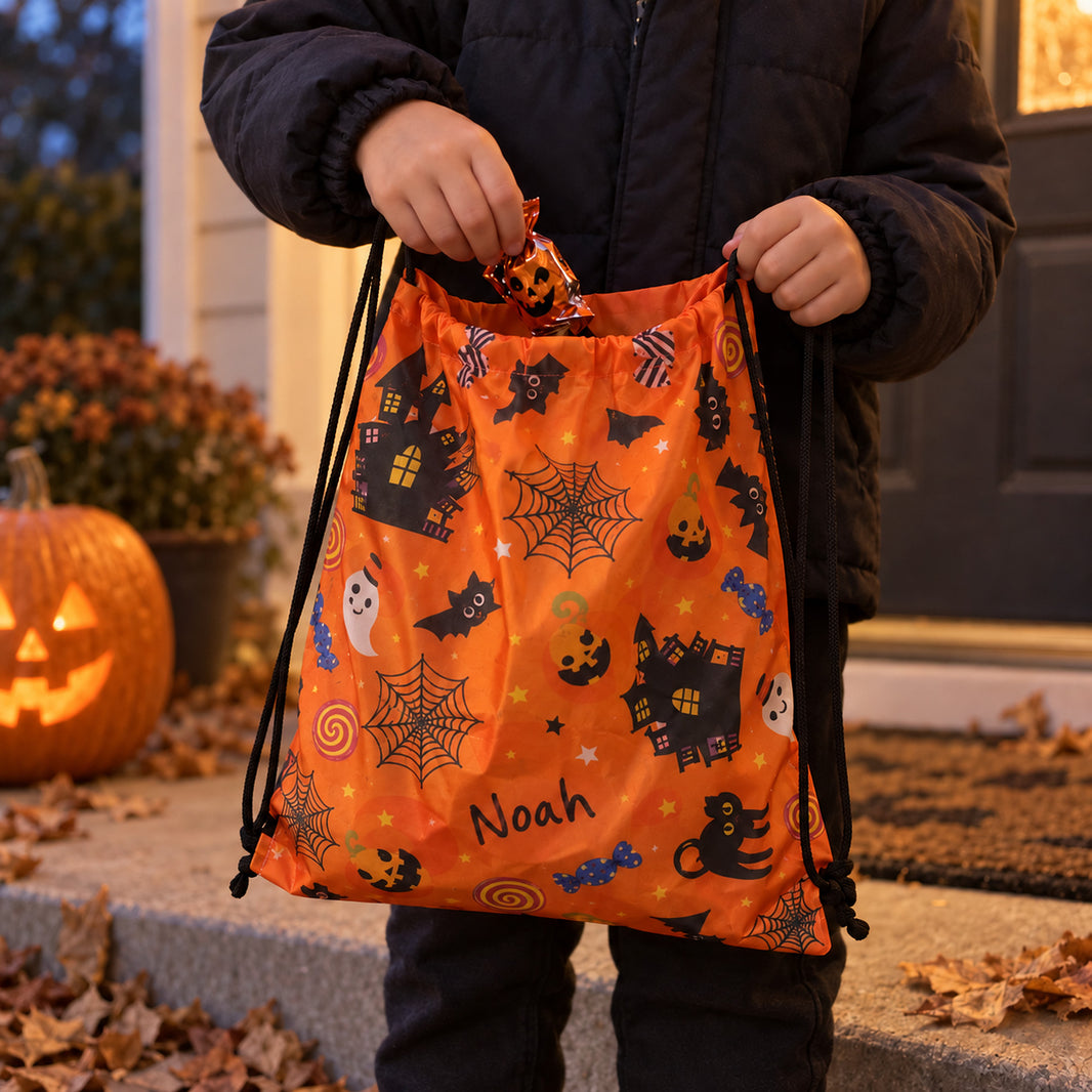 Child holding a personalised Noah Halloween drawstring bag open for sweets on a front porch beside a carved pumpkin