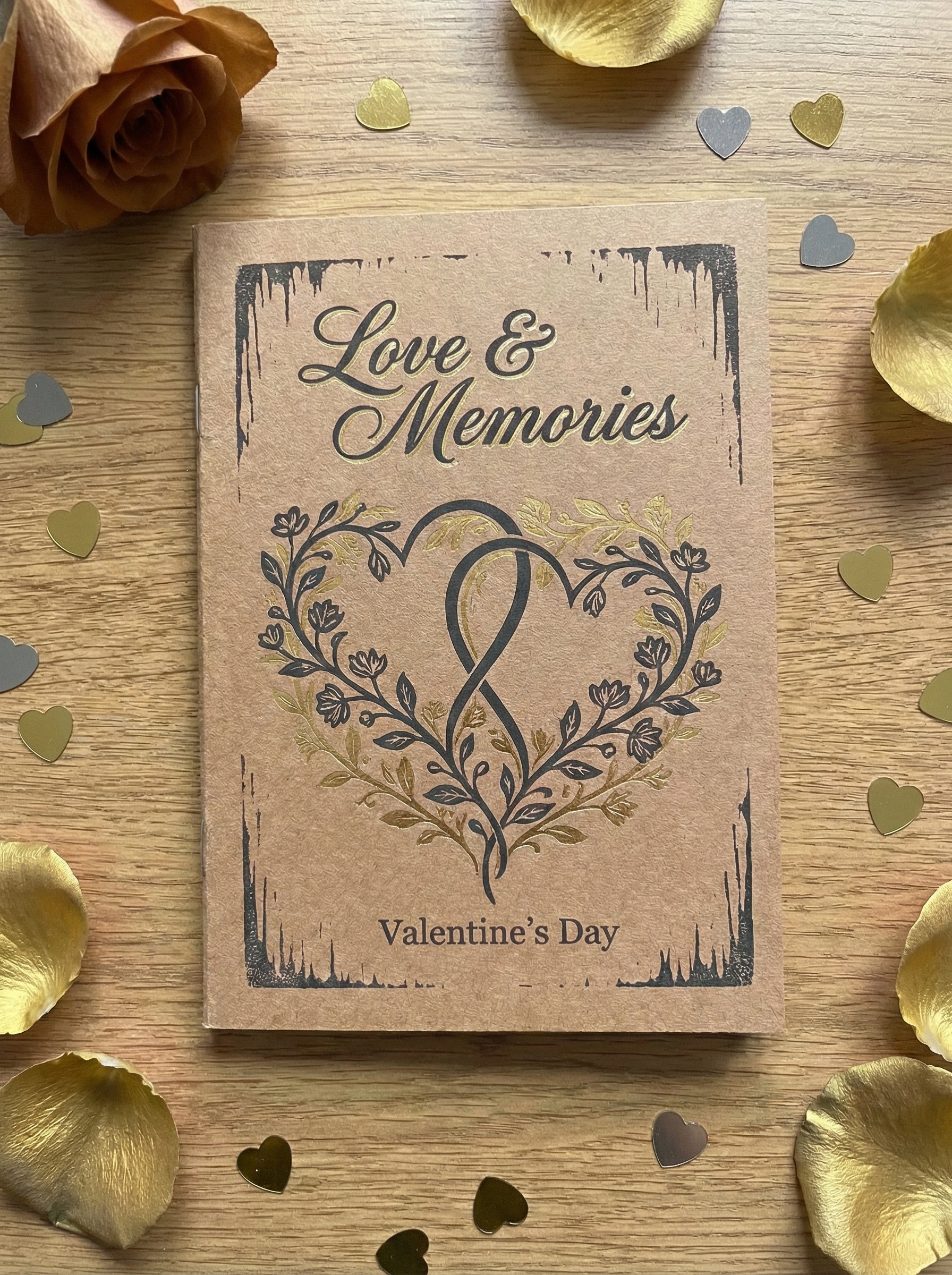 Card with 'Love & Memories' and 'Valentine's Day' text on a wooden surface with gold confetti and rose petals.