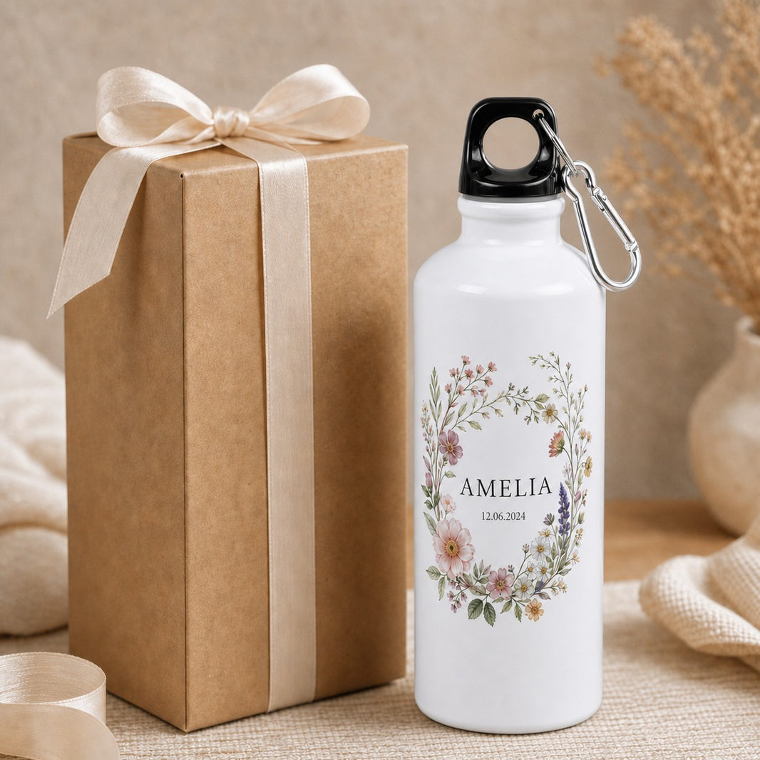 Bottle with name Amelia — floral wreath and date next to a wrapped gift box